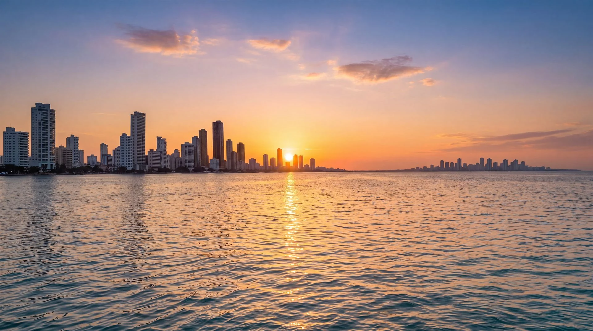 Puesta de sol dorada sobre la bahía y skyline de Cartagena